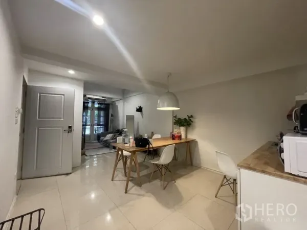Home Office for rent or sale in Watthana, Bangkok - Bright dining area with wooden table, pendant light and glossy tiled floors opening to the lounge.