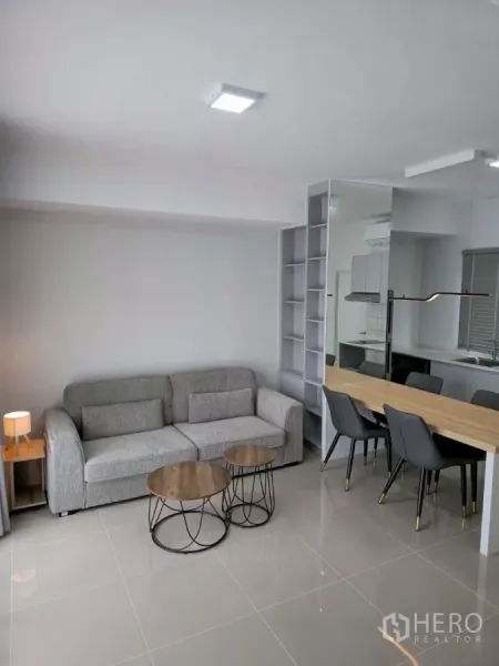 Townhouse for rent in Bang Phli, Samut Prakan - Bright living and dining area with gray sofa, nesting coffee tables and glossy tile floor.