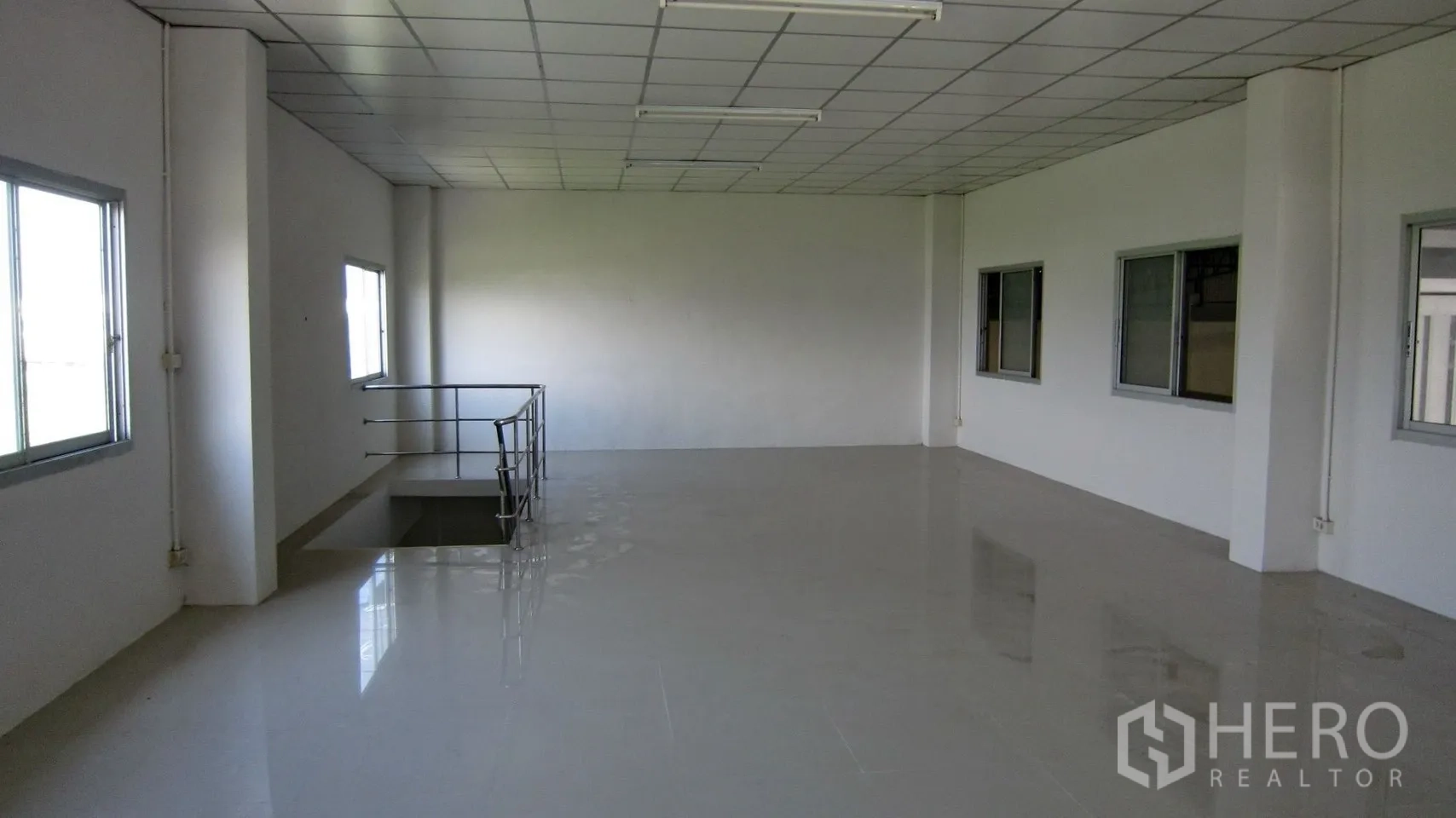 仓库 for rent in Bang Sao Thong, Samut Prakan - 仓库内夹层办公室，设多扇窗与楼梯入口。