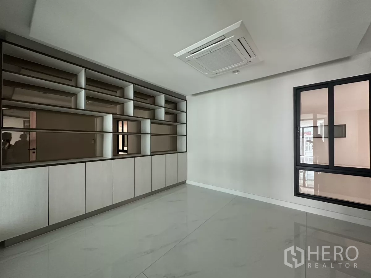Townhouse for rent in Watthana, Bangkok - Close-up of custom shelving cabinets and ceiling cassette air conditioner.