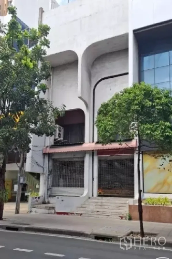 店屋 出租在Watthana, Bangkok - 临街多层店屋外立面，混凝土拱形线条与卷闸门台阶。