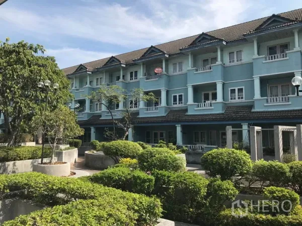 Office Space for rent in Khlong Toei, Bangkok - Low-rise blue building exterior with landscaped courtyard and greenery.
