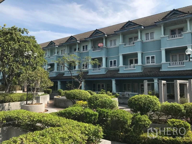 Office Space for rent in Khlong Toei, Bangkok - Low-rise blue building exterior with landscaped courtyard and greenery.