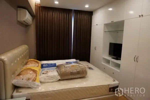 คอนโด ให้เช่าในWatthana, Bangkok - ห้องนอนอบอุ่น หัวเตียงบุผ้า ม่านทึบแสง และตู้บิวท์อินสีขาว