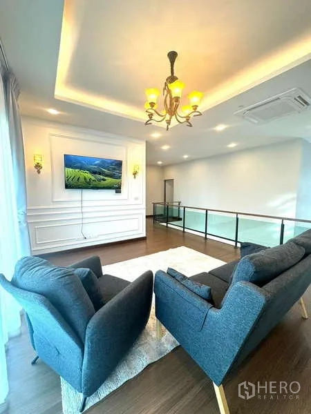 独立式住宅 出租在Bang Phli, Samut Prakan - 二层起居区，双人扶手椅、电视墙与玻璃栏杆