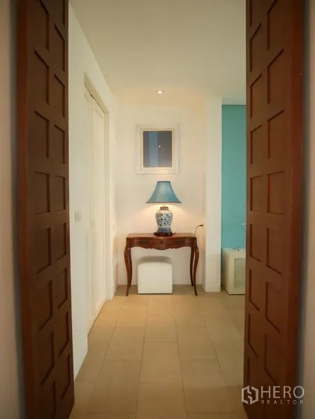 Condominium for rent in Khlong Toei, Bangkok - Hallway entry framed by wooden panels with a console table.