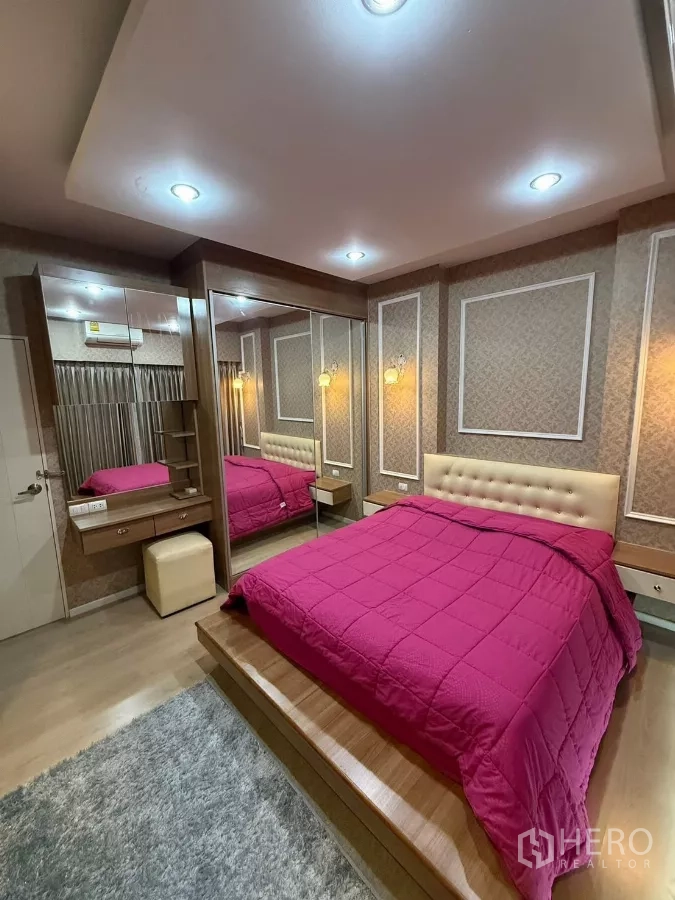 Townhouse for rent in Suan Luang, Bangkok - Third bedroom with platform bed, pink duvet and feature wall with mirrors.