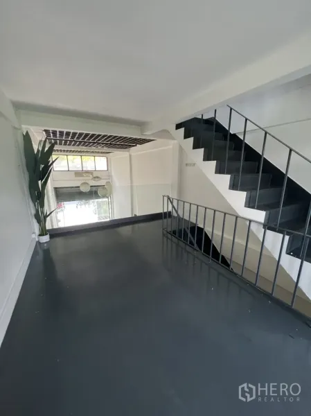 Shophouse for rent or sale in Watthana, Bangkok - Mezzanine level with metal staircase and railing overlooking the front hall.