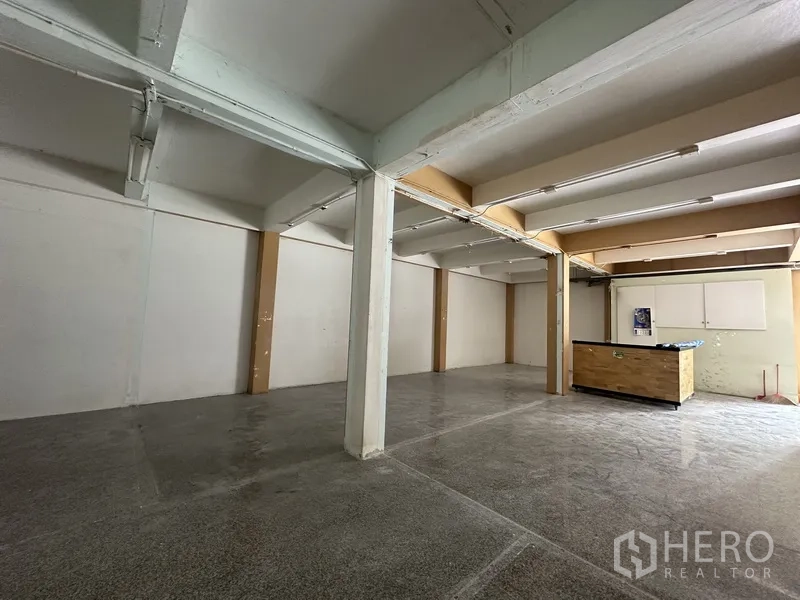 Retail Space for rent in Bang Rak, Bangkok - Spacious open-plan interior with white beams, support columns, and polished stone flooring.