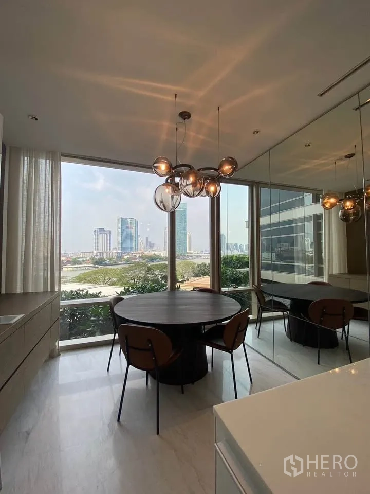 คอนโด for rent in Sathon, Bangkok - มุมทานอาหารพร้อมโคมไฟดีไซน์ ผนังกระจกเงา และทิวทัศน์แม่น้ำ.