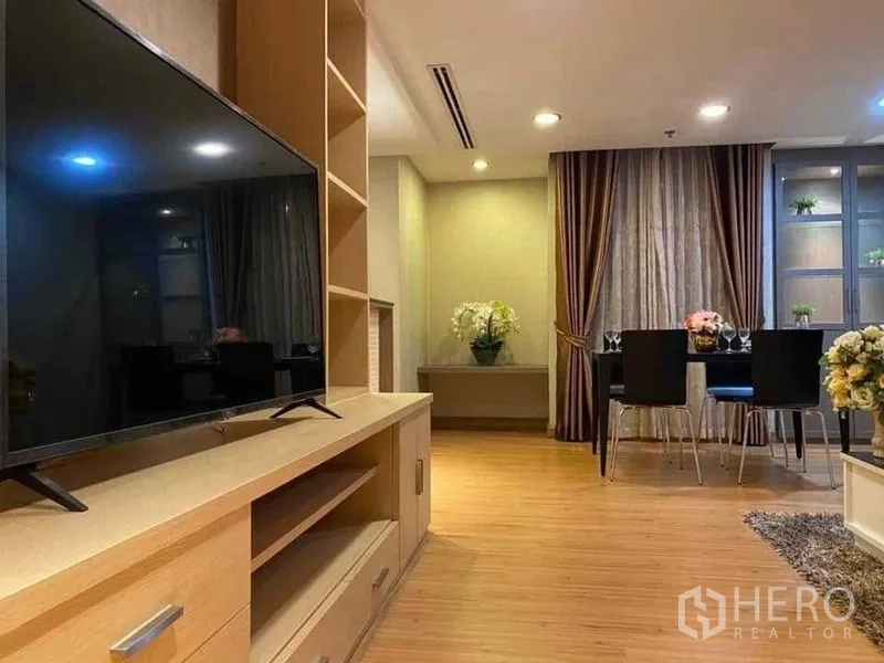 Condominium for rent in Watthana, Bangkok - TV console facing dining area with floor‑to‑ceiling drapes and recessed ceiling lights.