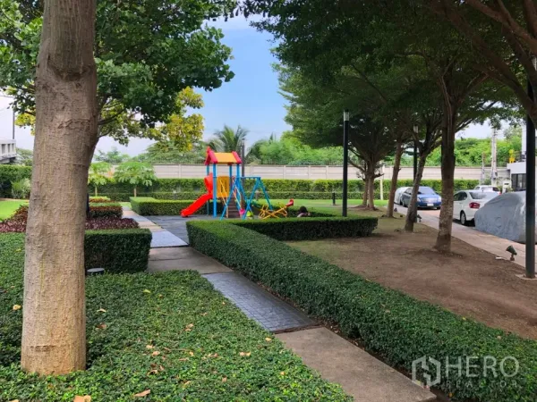 Townhouse for sale in Bang Kapi, Bangkok - Landscaped garden with shaded trees, walking paths and a colorful playground.