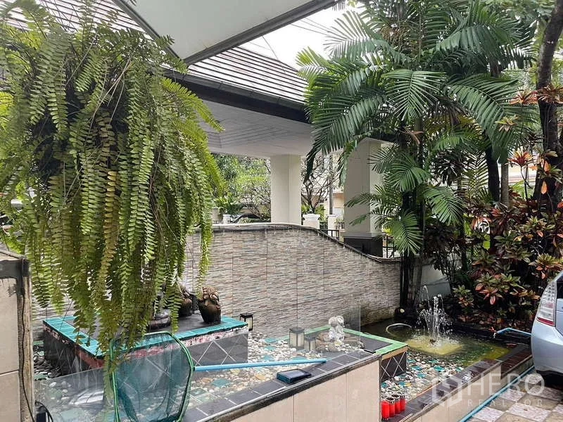 独立式住宅 出售在Suan Luang, Bangkok - 有顶车棚与景观水池，悬挂蕨类植物。