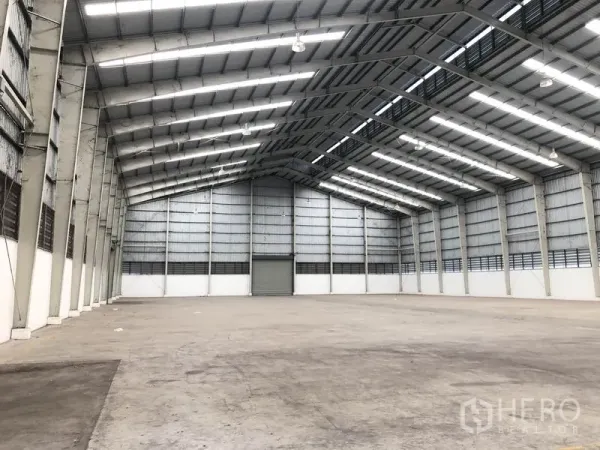 Warehouse for rent in Phra Nakhon Si Ayutthaya - Vast warehouse interior with high steel truss roof, skylights, and open clear span.