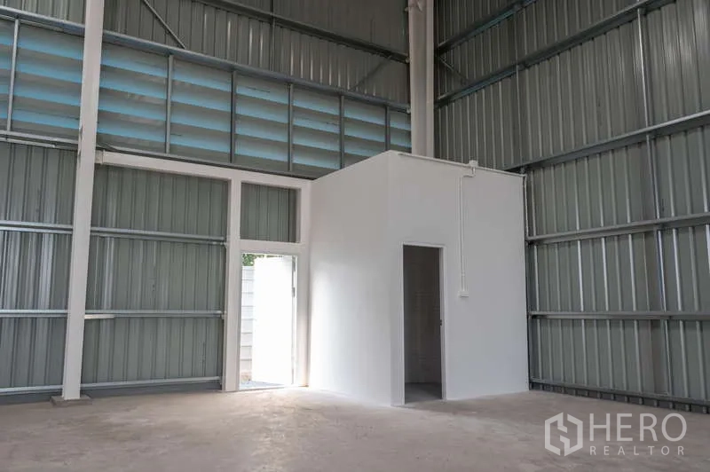 Warehouse for rent in Khlong Luang, Pathum Thani - Small white internal room for office or utilities beside a side access door.