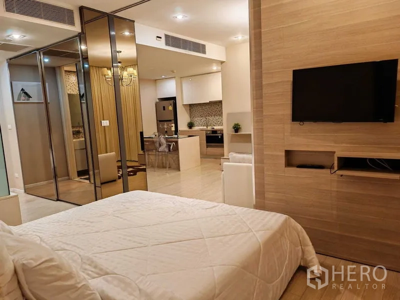 公寓 出租在Watthana, Bangkok - 卧室挂墙电视，面向开放式厨房与餐区