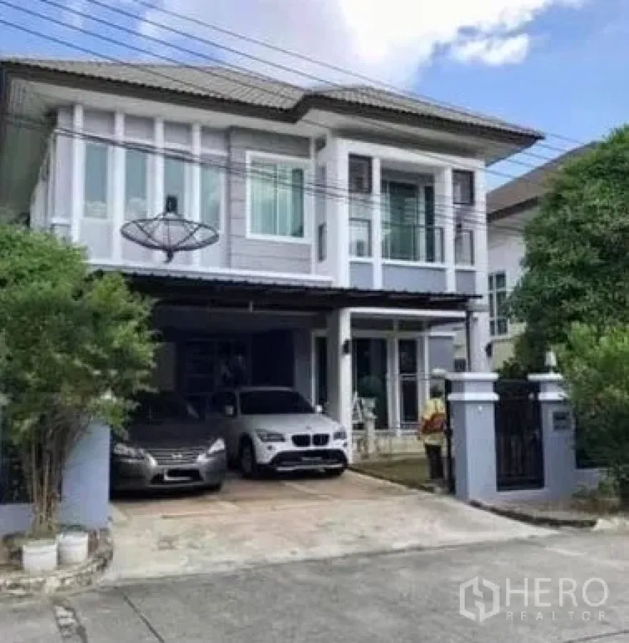 独立式住宅 出售在Khan Na Yao, Bangkok - 两层独栋别墅外观，带大门车道、双车位雨棚与阳台