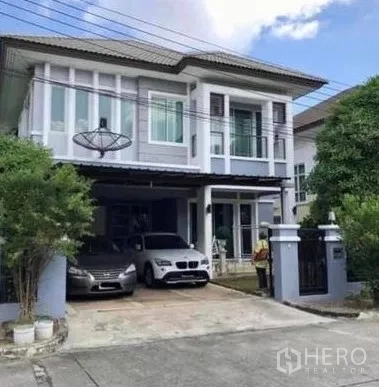 独立式住宅 出售在Khan Na Yao, Bangkok - 两层独栋别墅外观，带大门车道、双车位雨棚与阳台