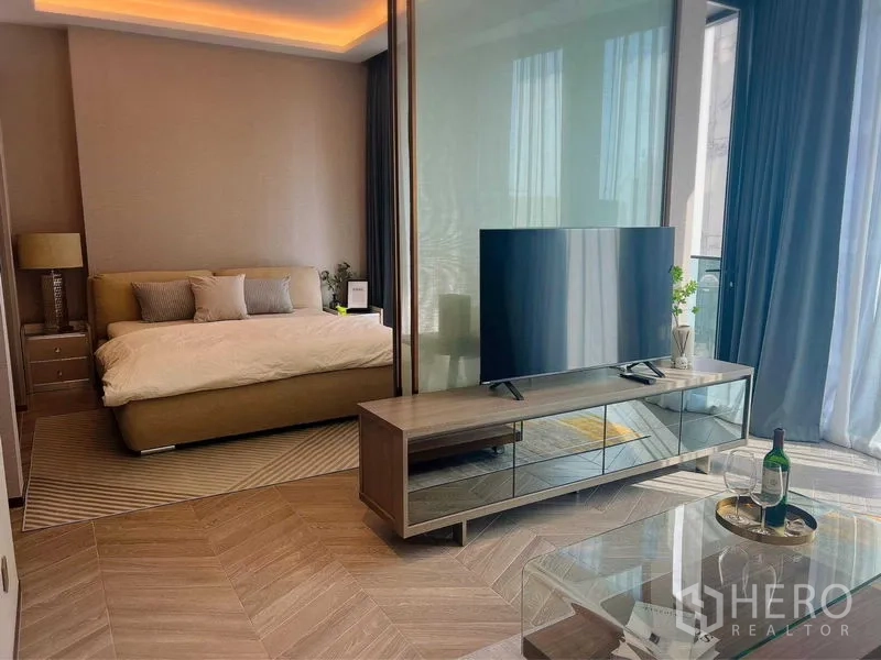 Condominium for rent in Khlong Toei, Bangkok - Open-plan view from kitchen to living area and balcony filled with natural light.