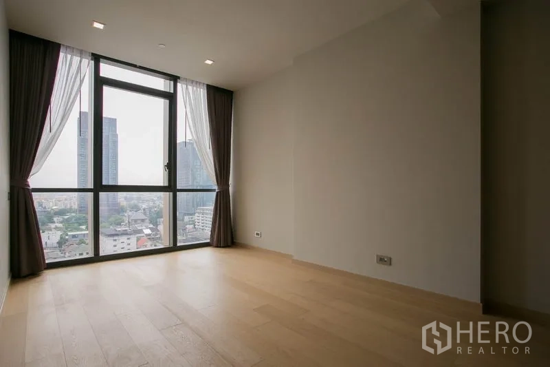 公寓 出租或出售在Watthana, Bangkok - 宽敞卧室，超高窗户与窗帘，眺望天际线。