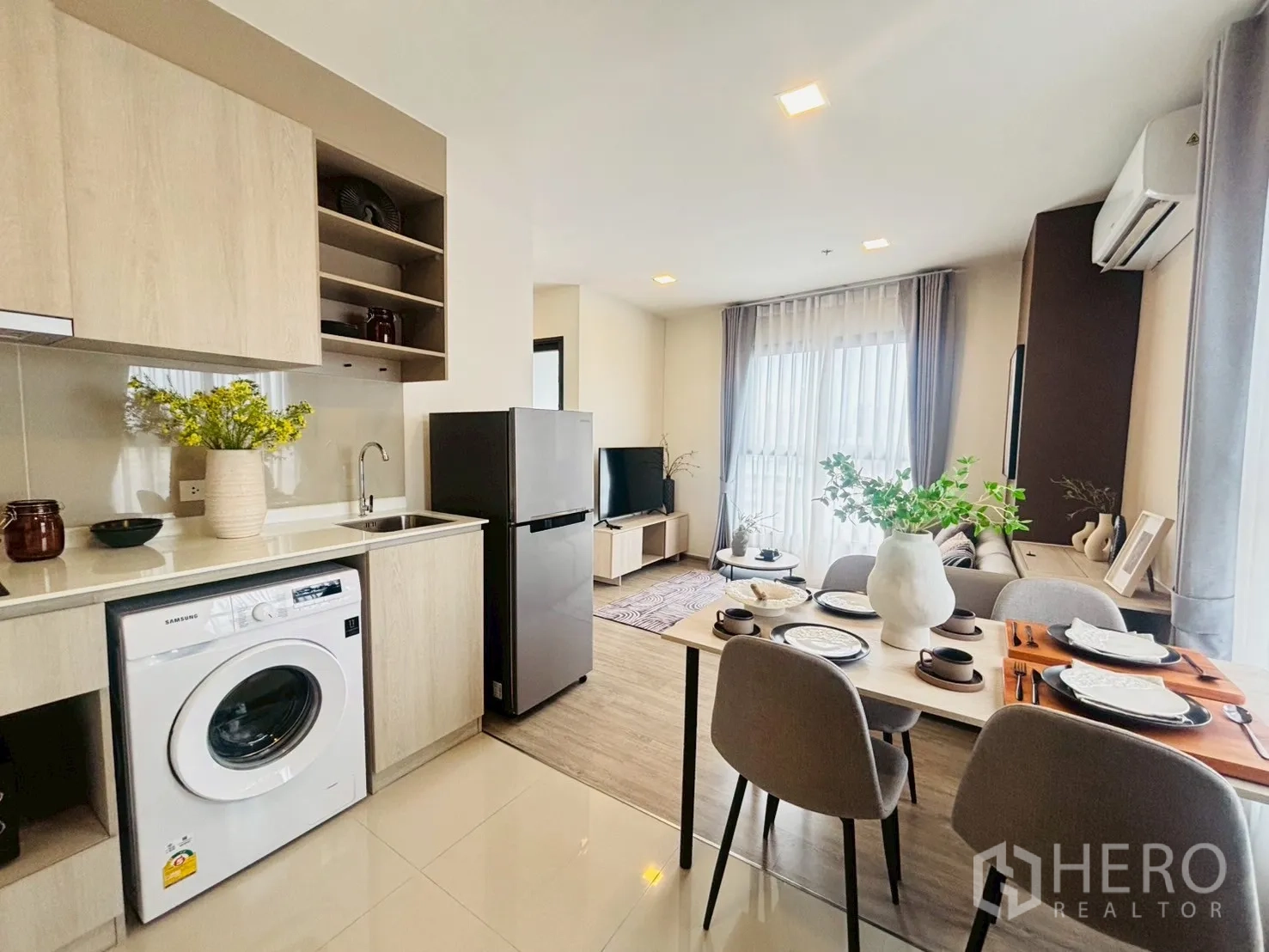 公寓 for rent in Watthana, Bangkok - 现代浅木色小厨房，带水槽与置物架，旁侧为布置好的餐桌。