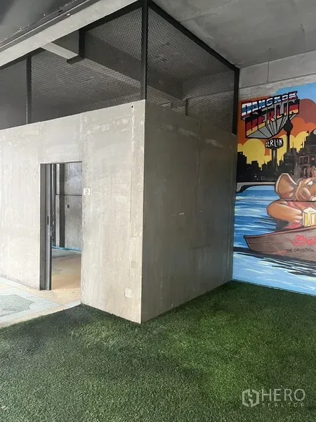 Retail Space for rent in Watthana, Bangkok - Concrete service room with mesh top beside a river-themed mural and green turf.