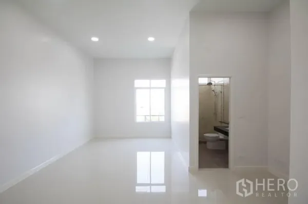 Home Office for sale in Huai Khwang, Bangkok - Bright white office room with glossy tile floor, a window and an ensuite bathroom.