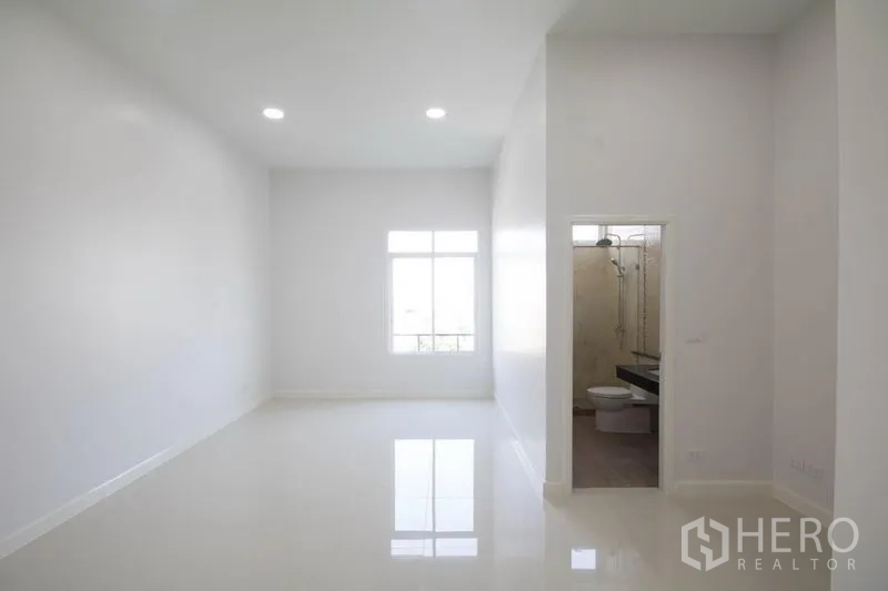 Home Office for sale in Huai Khwang, Bangkok - Bright white office room with glossy tile floor, a window and an ensuite bathroom.
