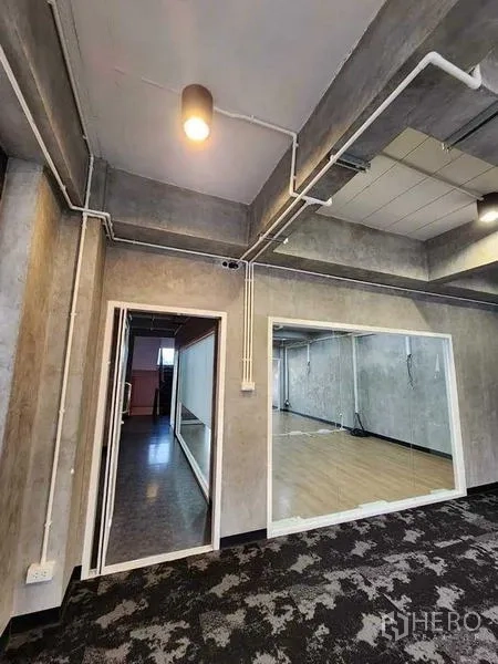 办公空间 出租或出售在Bueng Kum, Bangkok - 走廊及休闲区，设大型内窗、外露管线与花纹地毯。
