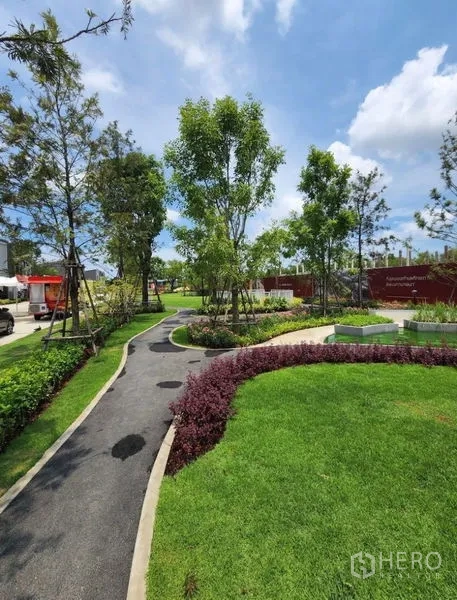 Townhouse for rent in Bang Phli, Samut Prakan - Landscaped community garden with winding pathway, lawns, and mature trees.