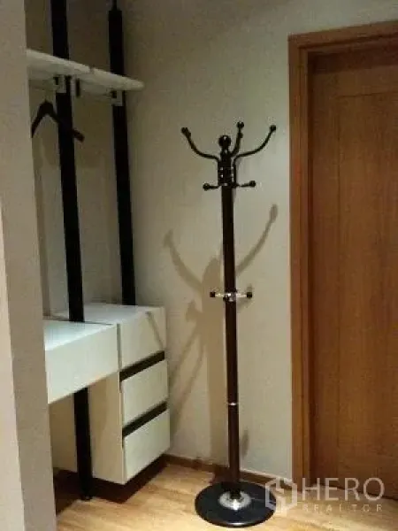 Condominium for rent or sale in Khlong Toei, Bangkok - Walk-in closet with open hanging rails, drawers, and a standing coat rack.