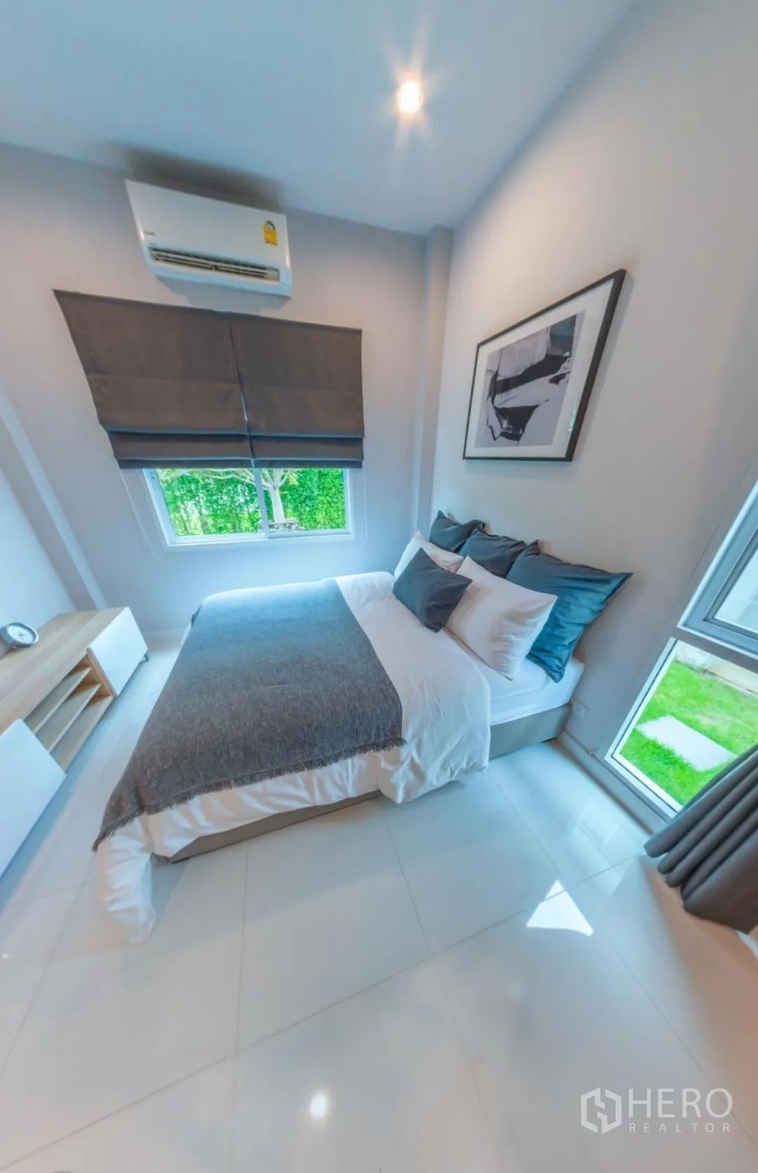 Detached House for rent in Lam Luk Ka, Pathum Thani - Cozy bedroom with double bed, air-con, and corner windows overlooking greenery.