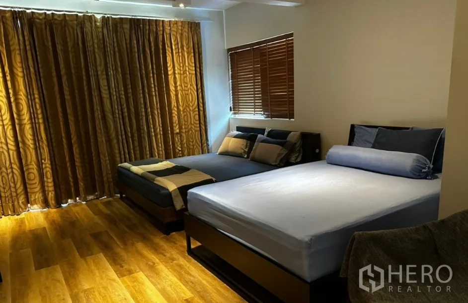 联排别墅 for rent in Sathon, Bangkok - 宽敞卧室设两张床、木地板与百叶窗。