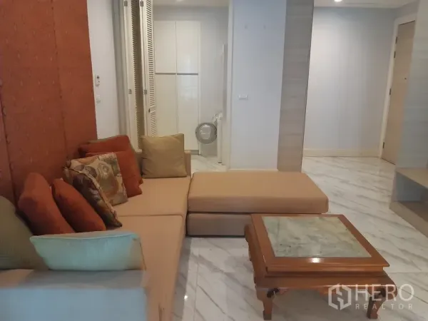 Condominium for rent or sale in Khlong Toei, Bangkok - Cozy lounge with sectional sofa, marble-top coffee table and sleek flooring beside the entry hall.