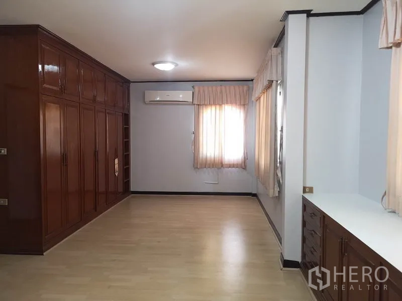 Detached House for sale - Spacious bedroom with wall-to-wall wooden wardrobes, air conditioner and wood floors.