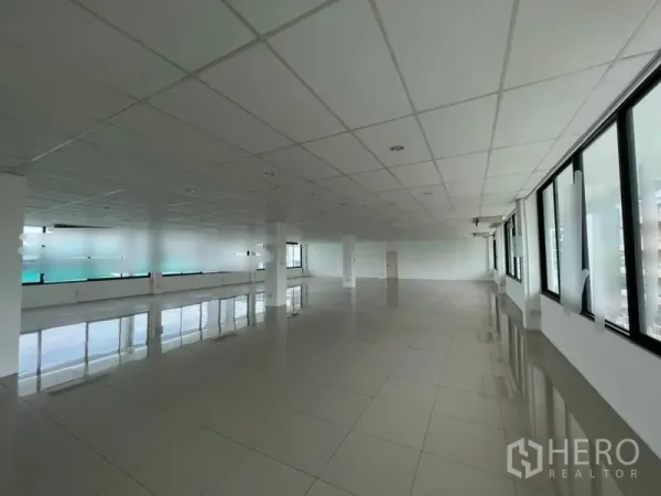 สำนักงาน ให้เช่า - ภายในออฟฟิศกว้าง มีเสาโครงสร้าง ฝ้าทีบาร์ และหน้าต่างด้านข้างให้แสงสว่าง