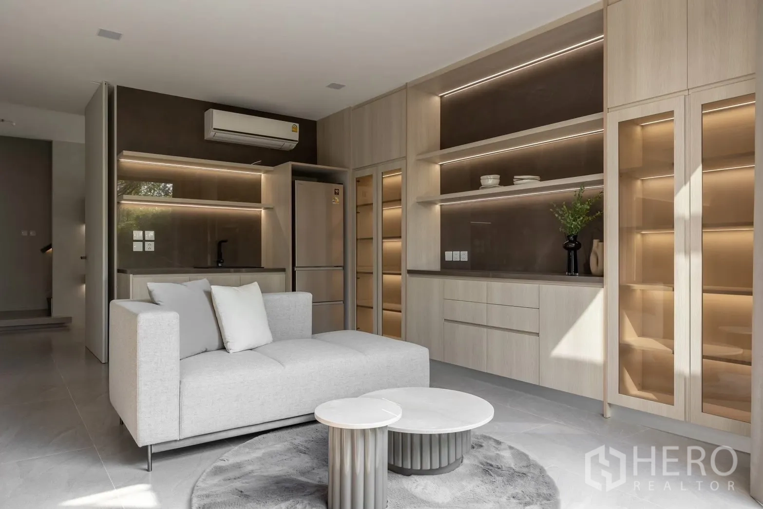 Detached House for rent in Saphan Sung, Bangkok - Secondary living area with display cabinets, refrigerator, and neutral sofa.