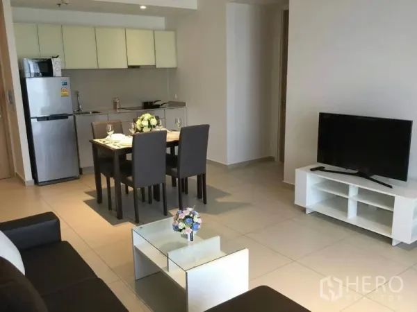 公寓 出租在Watthana, Bangkok - 现代客厅视角，可见餐桌、简洁厨房与电视柜。