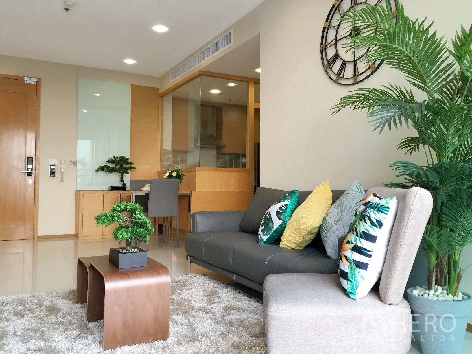 公寓 出租或出售在Khlong Toei, Bangkok - 客餐一体起居区，沙发、绿植与紧邻厨房的用餐角。