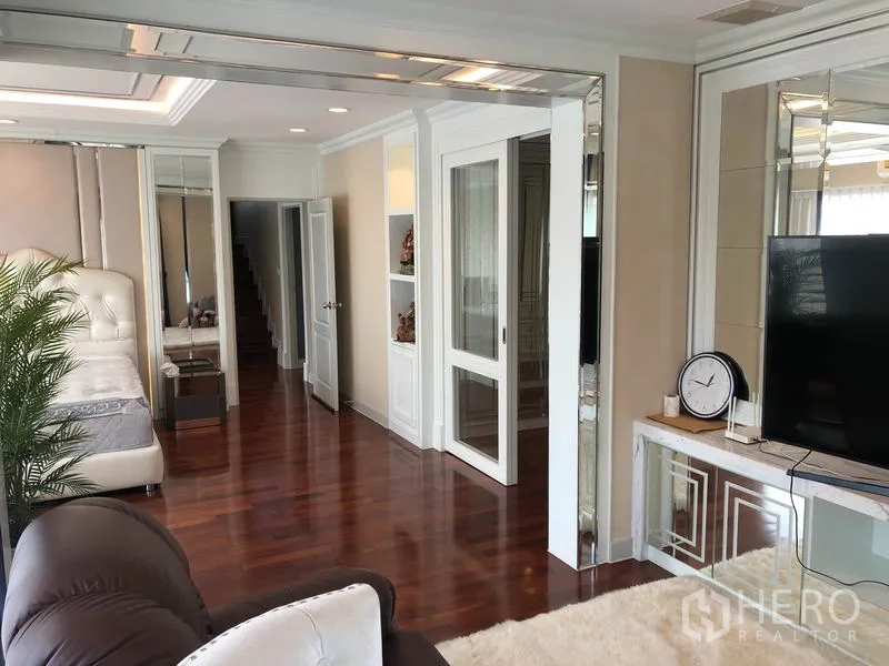 Detached House for rent or sale in Saphan Sung, Bangkok - Master suite sitting area with polished wood floors and built-in cabinetry.
