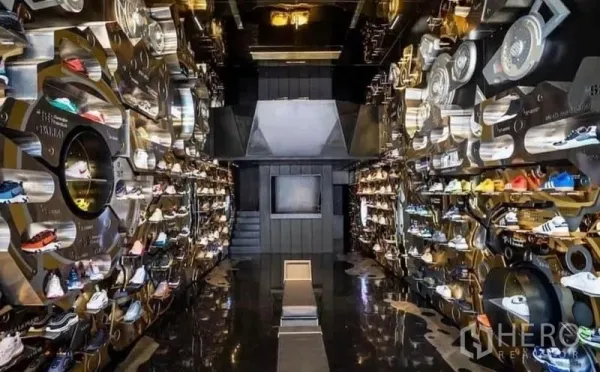 Shophouse for rent in Khlong Toei, Bangkok - High-end sneaker retail interior with mirrored floor and illuminated wall displays.