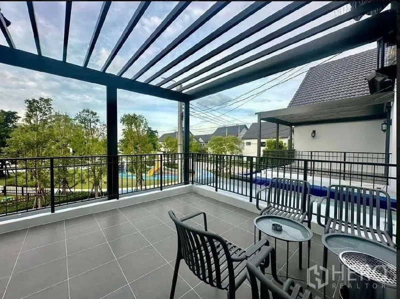 Detached House for rent in Bang Phli, Samut Prakan - Spacious covered terrace with pergola roof and outdoor seating overlooking a park.