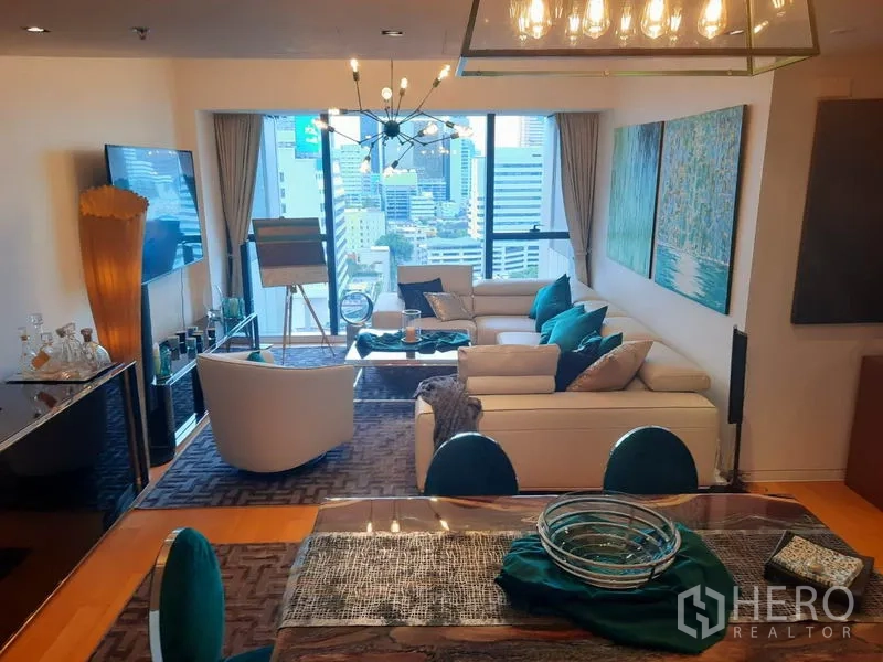คอนโด ให้เช่าหรือขายในSathon, Bangkok - ห้องนั่งเล่นสไตล์โมเดิร์น มีโคมไฟระย้า โซฟาสีขาว และกระจกเต็มบานชมวิวสกายไลน์กรุงเทพฯ