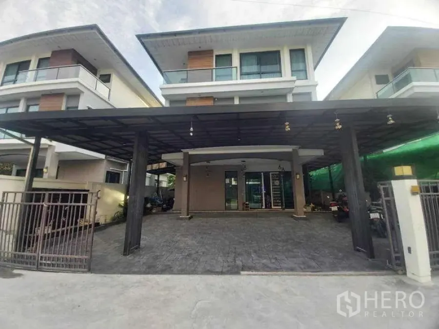 Detached House for rent or sale in Prawet, Bangkok - Front view of the detached house with wide carport and balcony.