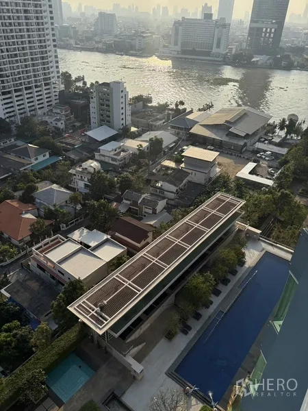 公寓 for rent in Khlong San, Bangkok - 鸟瞰长泳池、日光躺椅区与临河社区。