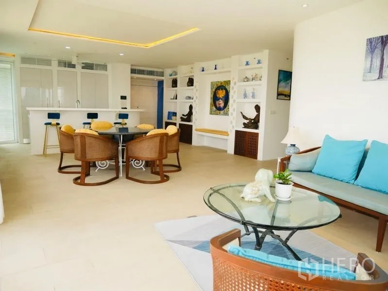 Condominium for rent in Khlong Toei, Bangkok - Bright open-plan living room with dining set, built-in shelves and a white kitchen island.