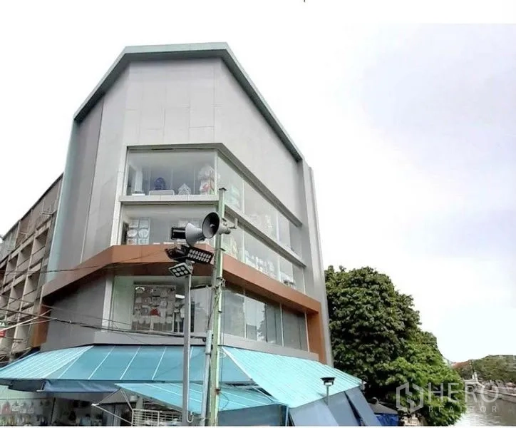 店屋 出租在Pathum Wan, Bangkok - 多层商铺外立面斜角视图，配大面积展示窗与简洁线条。
