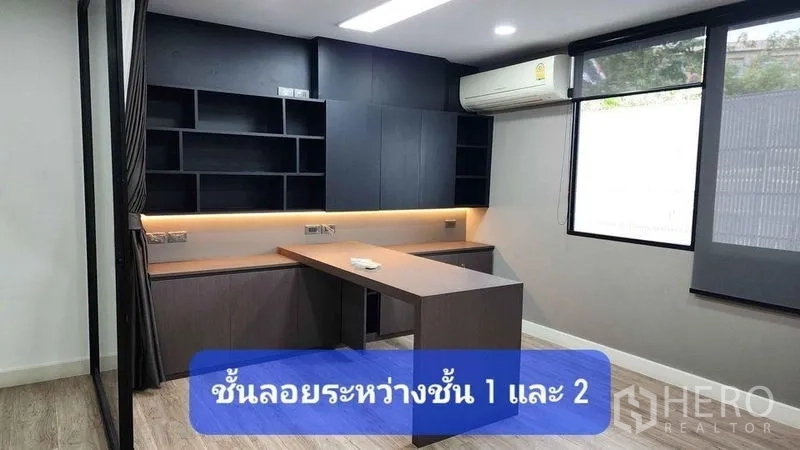 Townhouse for rent in Bueng Kum, Bangkok - Modern study with built-in black cabinetry, L-shaped desk, LED strip lighting, large window and air conditioner.