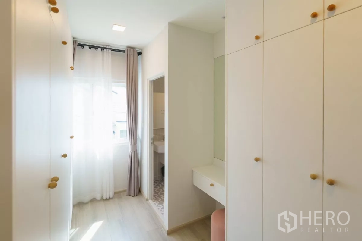 Detached House for rent in Bang Phli, Samut Prakan - Walk-in wardrobe corridor with built-in closets and vanity leading to bathroom.