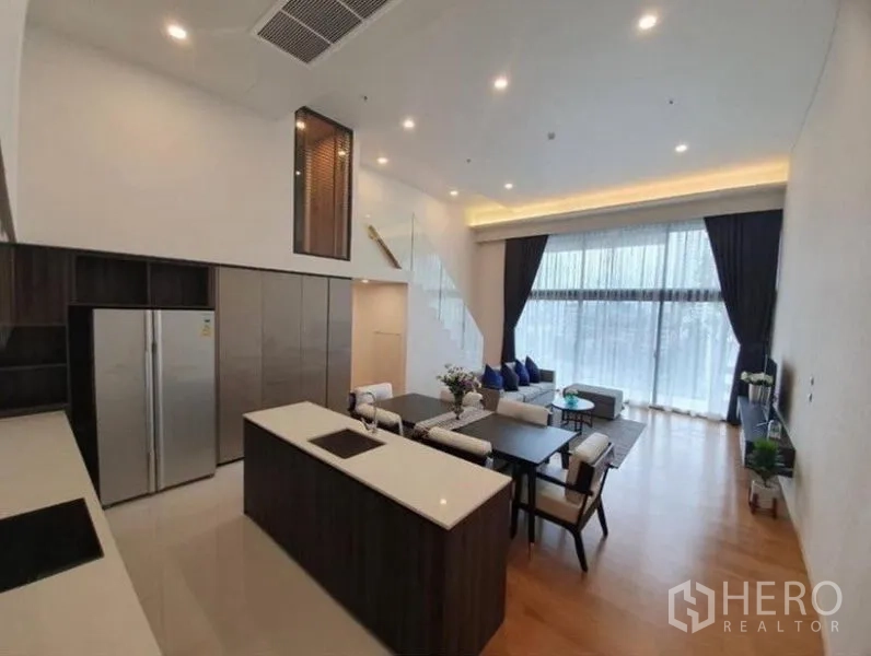 คอนโด ให้เช่าในWatthana, Bangkok - ครัวทันสมัยมีไอส์แลนด์ เตาอินดักชัน ตู้บิลท์อิน และตู้เย็นสองประตู เปิดสู่พื้นที่นั่งเล่นสว่าง